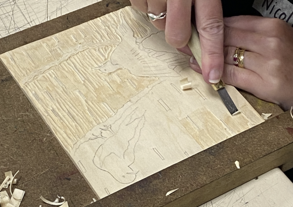 An image of birds being carved into a piece of plywood