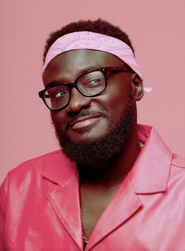 Photo of Elvin James Mensah in a pink suit on a pink background