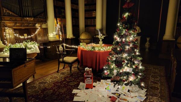 A room with light up christmas trees and lights in with letters on the floor