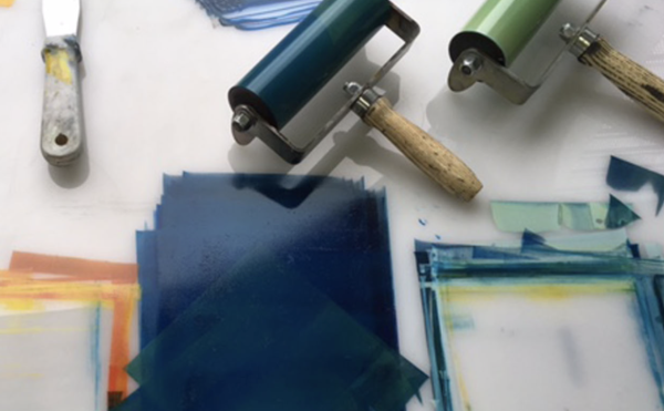 Ink rollers and inks being rolled on a white surface