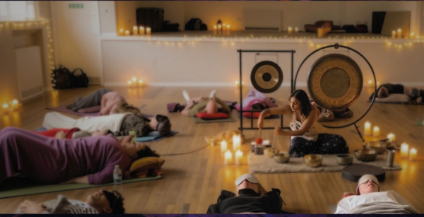 Neeta from Sarl Sound Healing delivering a sound bath in Meanwood Community Centre surrounded by candles