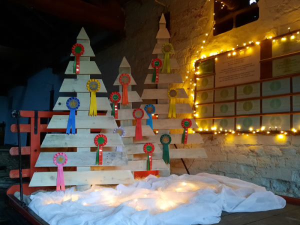 Christmas trees made from wooden pallets in front of fairy lights