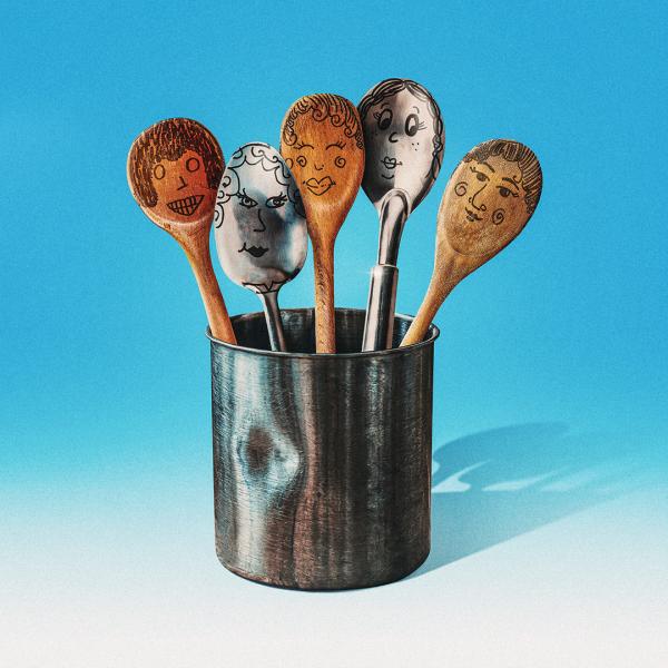 In a tin pot, several silver and wooden spoons with comic faces illustrated in black pen.