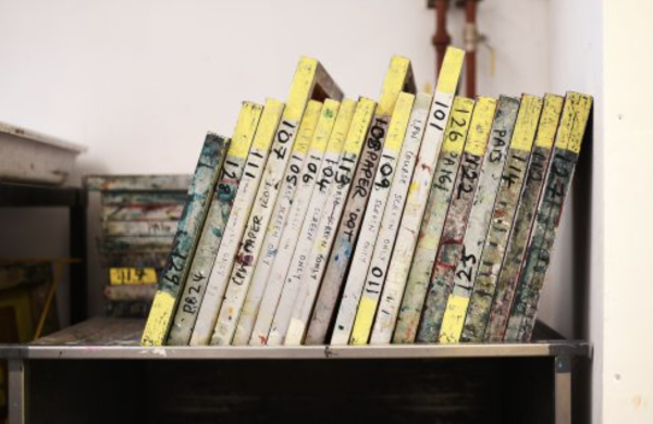 A range of different sized screen printing screens stacked on a shelf