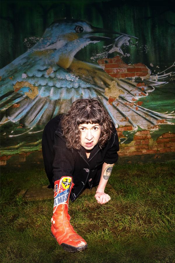 a woman crawling on the floor in front of a wall mural of a kingfisher bird capturing a fish