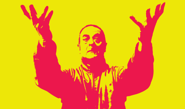 Comedian Mark Thomas stands arms upraised palms uppermost with fingers splayed, like he's imploring the world to strive for better, mind you in the rhubarb and custard colour scheme he does have a touch of Kevin McCloud from Grand Designs about him