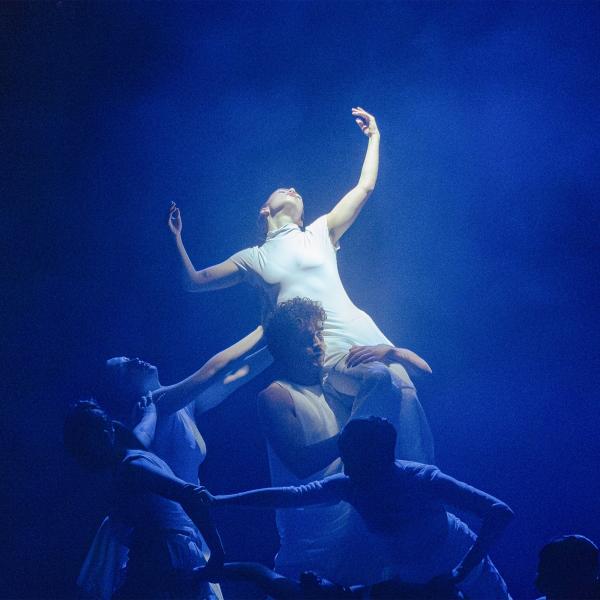 Dancer is held on the shoulder of another dancer