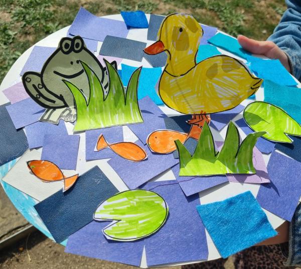 A 3D pond-themed collage consisting of paper ducks, fish, frogs and lily pads.