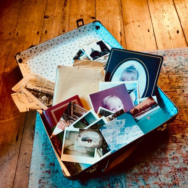 A photograph of an open suitcase containing lots of family photos