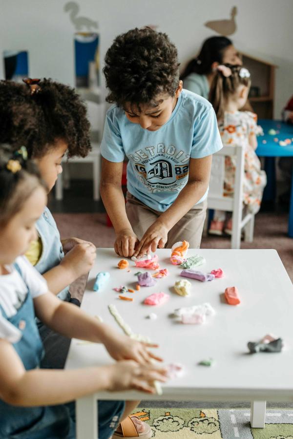 Children playing with clay, making animal shapes.