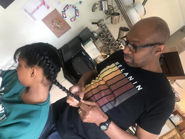 Errol, founder of Leeds Dads plaiting his child's hair