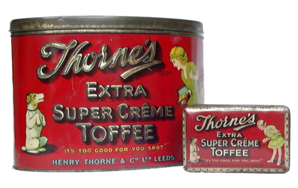 Large and small red confectionery tins advertising “Thorne’s Extra Super Crème Toffee”, with the slogan “It’s too good for you, Spot” and illustrations of a dog and a person holding sweets.