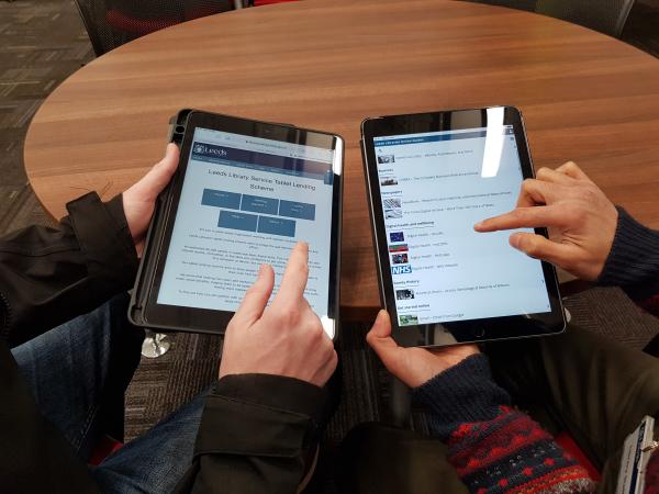 Two people looking at tablets