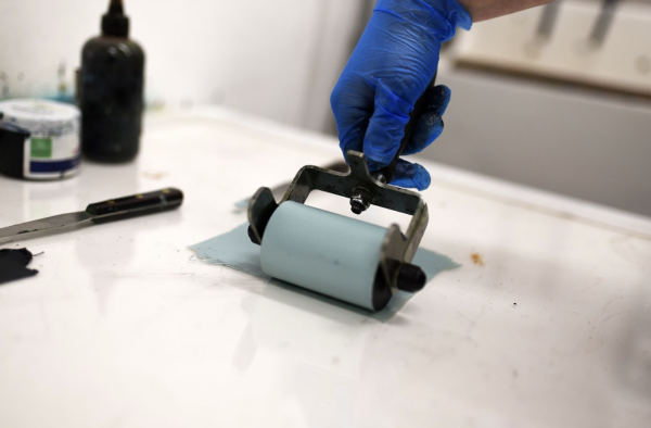 An ink roller being used to roll out light blue ink.