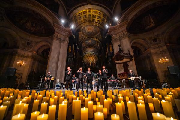 Live band performing in a stunning candlelit cathedral.