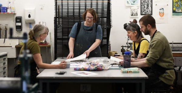 Agroup of artists enjoying a creative session in a printmaking studio
