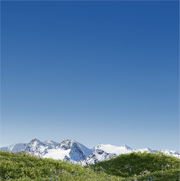 Picturesque landscape of snow-capped mountains and luscious green grass with clear blue sky.