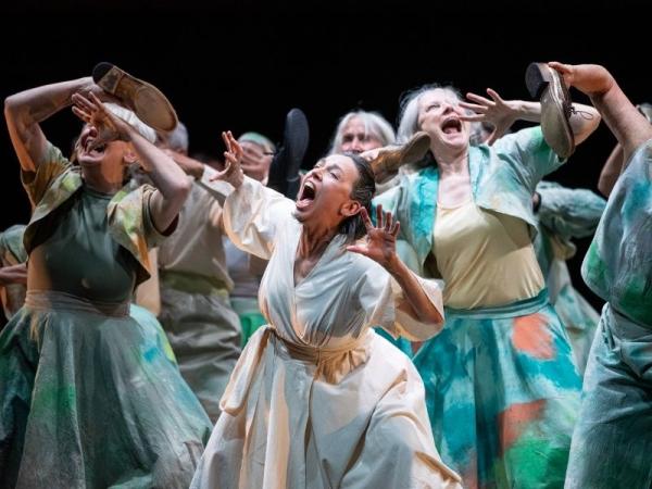 A group of older women writhe on stage as if screaming
