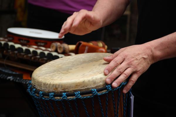 Someone playing a drum with their hands