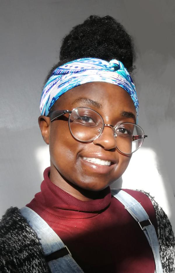Photographic portrait of Salomey Doku wearing blue patterned bandana and dungarees 