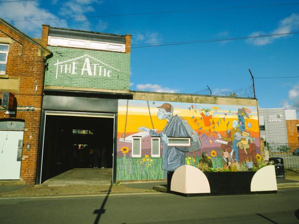 A picture of the outside of The Attic, a venue in Leeds, featuring colourful street art