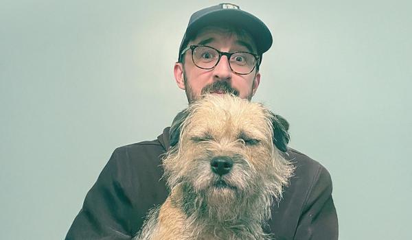 a man and a border terrier