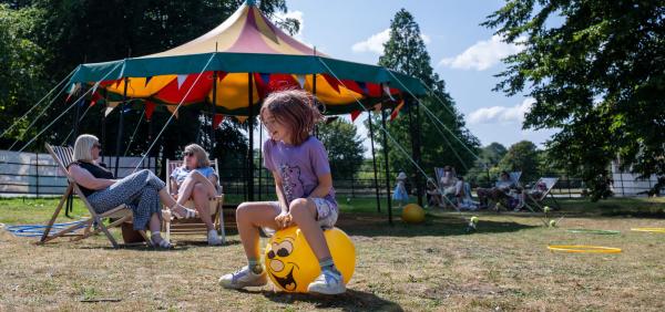 Older child bouncing on a yellow hop ball