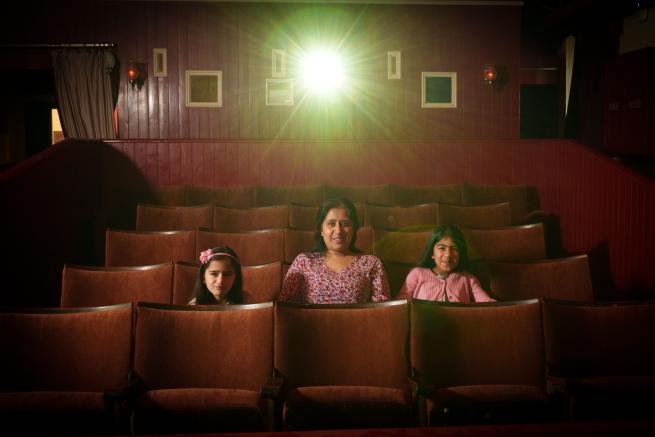 Family sat in cinema chairs