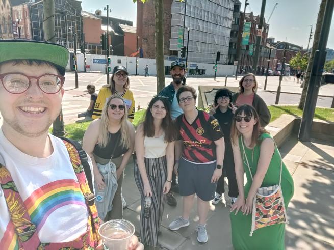 A selfie with 8 people smiling in the background