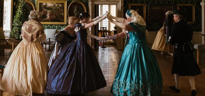 a photo of the Arbeau Dancers at Temple Newsam House in period dress, dancing.