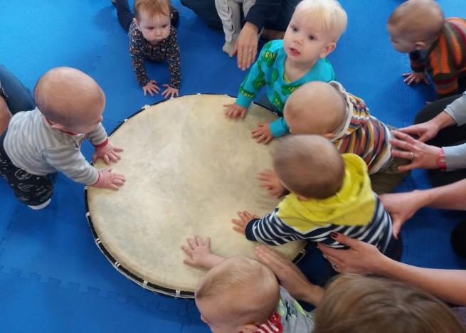 Image of babies around a large drum
