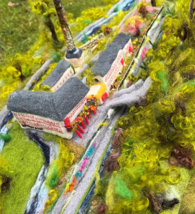 A felted version of Armley Mills, with small felted buildings, surrounded by felted green trees