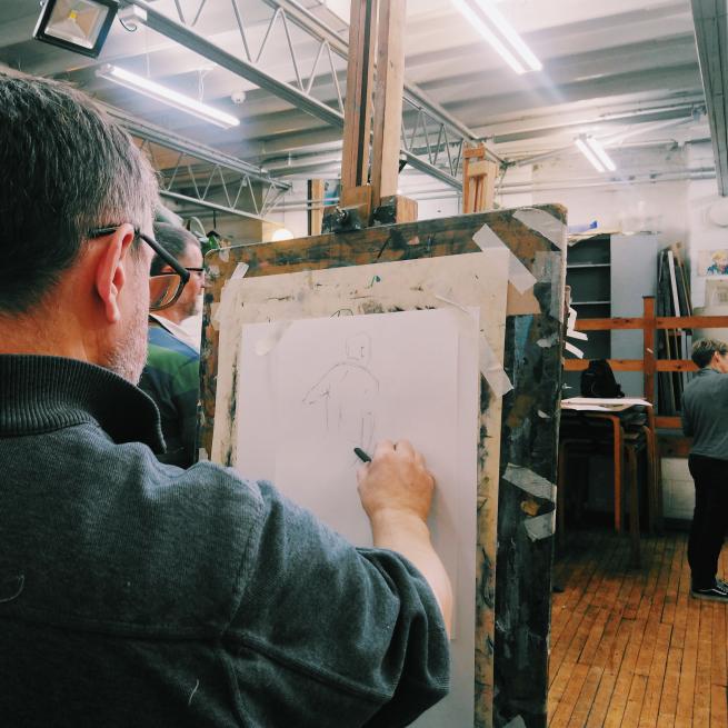 A photograph of a person using an easel and life drawing