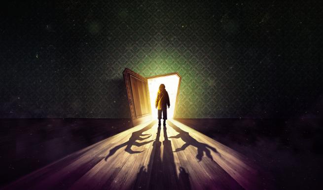 A young girl wearing a yellow anorak stands facing an open door. Bright light cascades out causing shadows across the old wooden floor. Two boney hands reach around the girl in the dark. Above the door, etched into green wallpaper, are the words ‘Coraline - A Musical’. 