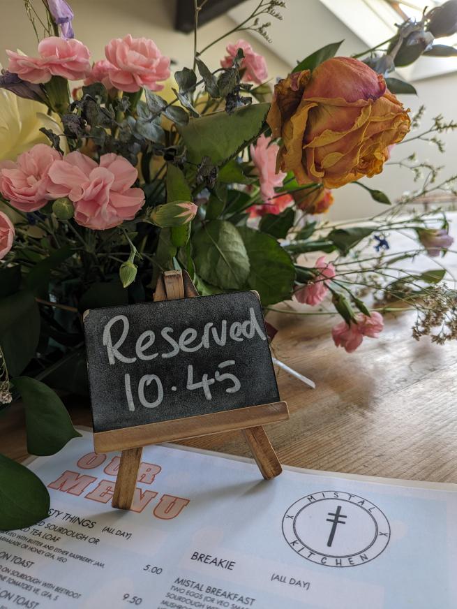 A reserved sign with flowers sat on a menu