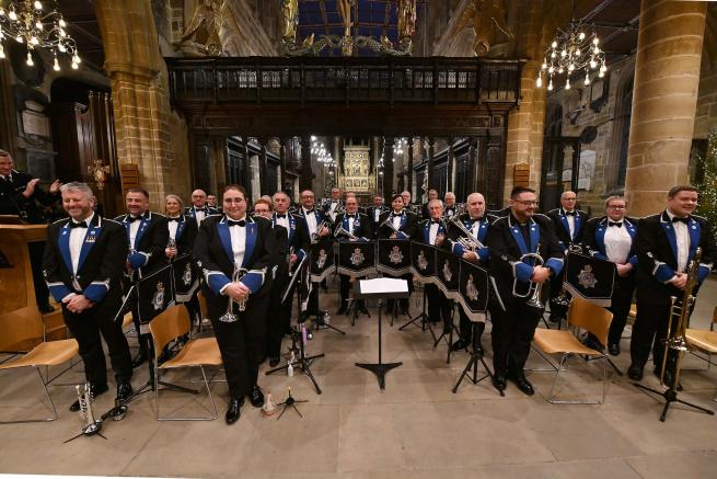 The West Yorkshire Police Band gathered in uniform in a church building 