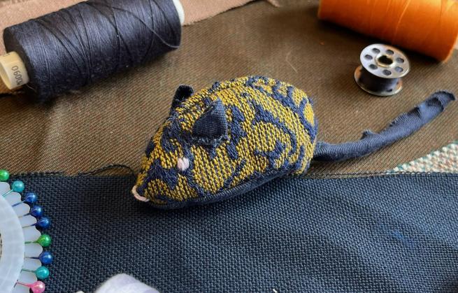 Fabric mouse surrounded by sewing materials