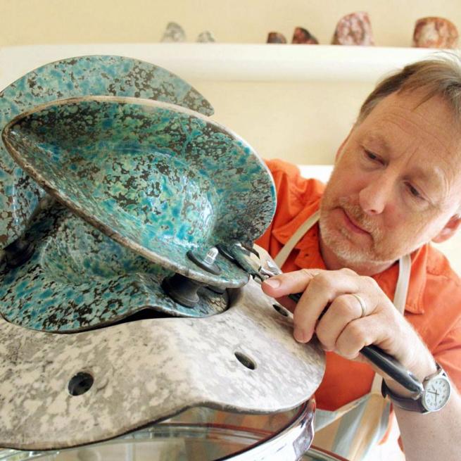 Sculptor, Eric Moss, works in his studio on a ceramic piece