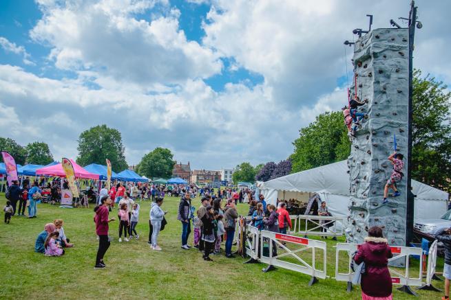 a picture of the 2023 Gala showing stalls, cafe tent, climbing wall and lots of people having fun