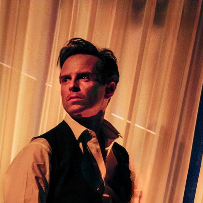Andrew Scott wearing a dress shirt and a black waist coat looking over his right shoulder. 