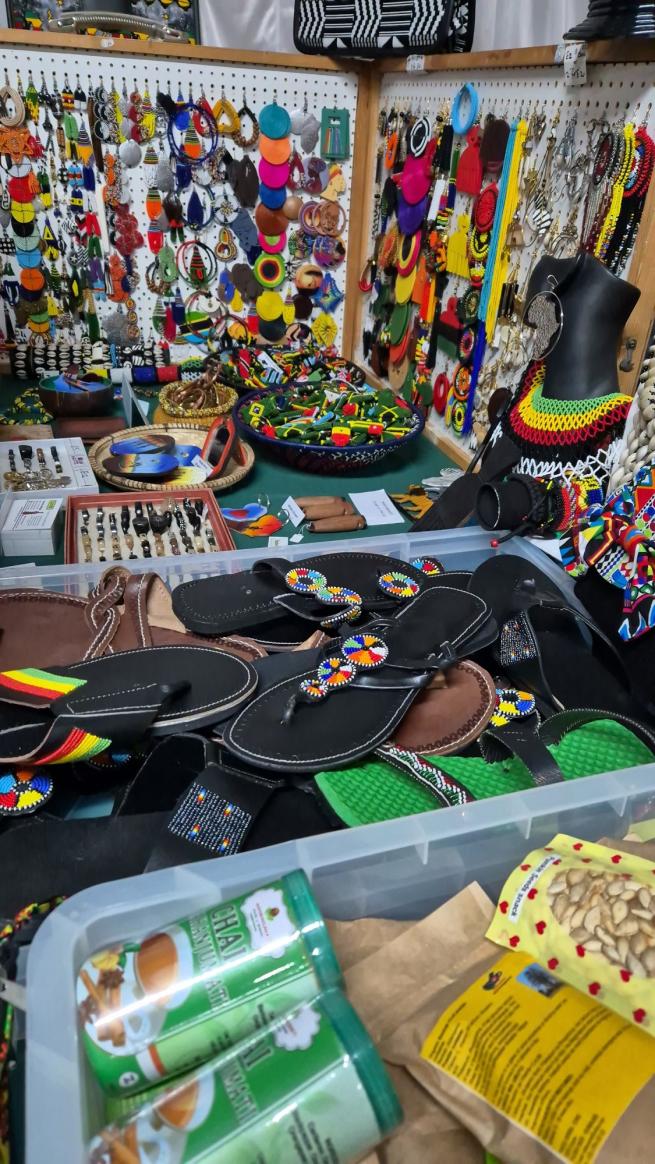A colourful picture displaying lots of African food, jewellery and shoes 