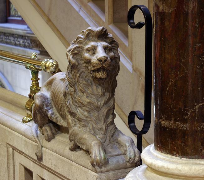 Sculpture of a lions head on the library staircase