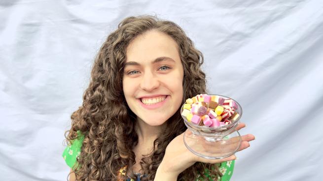 a picture of a long haired lady holding up an icecream sundae to the camera.
