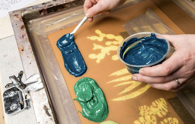 Blue and green ink being applied to a screen with a design of succulent plants