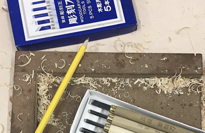 Woodcutting tools and a pencil, surrounded by wood shavings