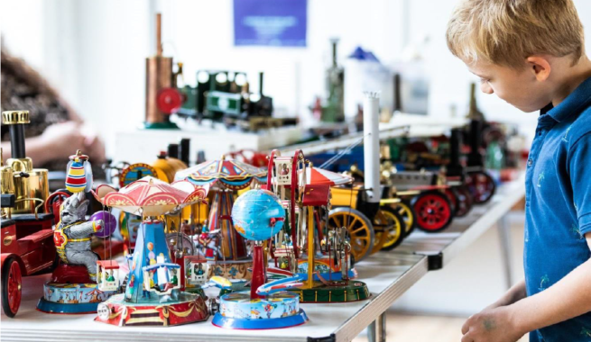 A table full of engineering toys, with a young person looking 