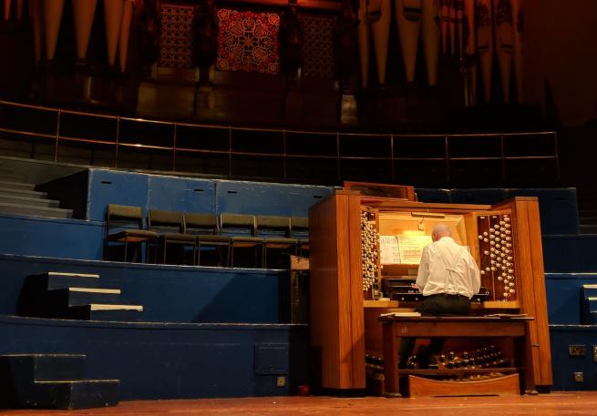 A musician sat playing the organ. 