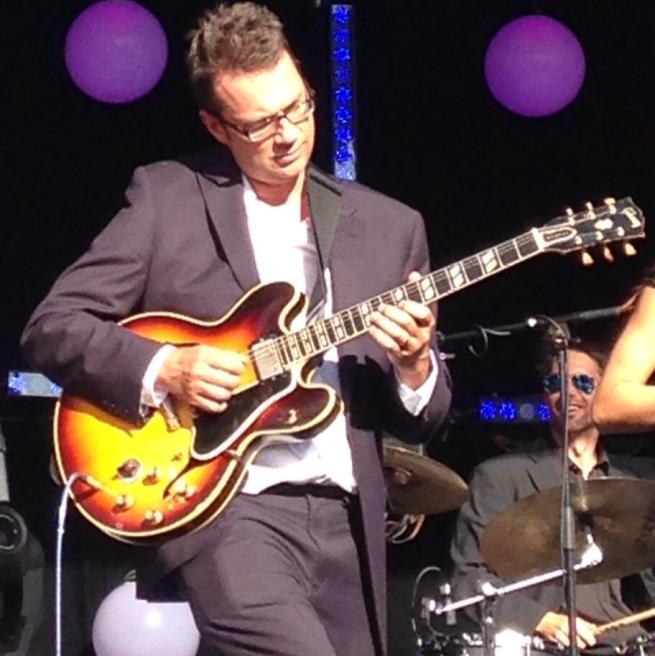 Al Morrison playing guitar on stage 