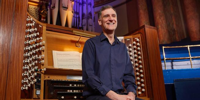 A musician sat on the organ bench. 