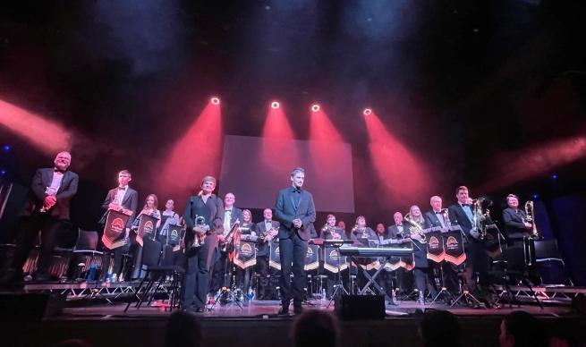 A brass band performing on a stage. 